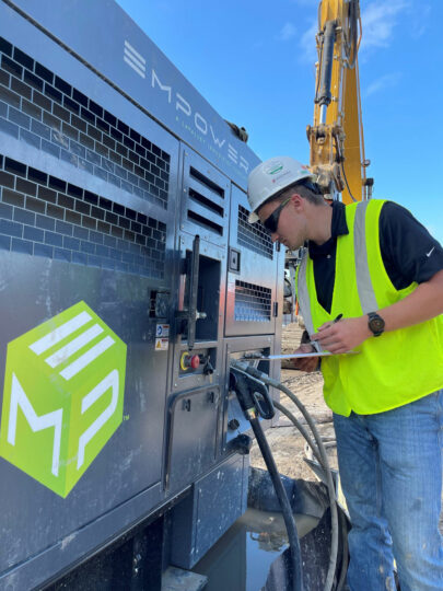 A technician reviews the smart health telematics displayed on a touch screen monitor embedded within the EMP™40 generator.