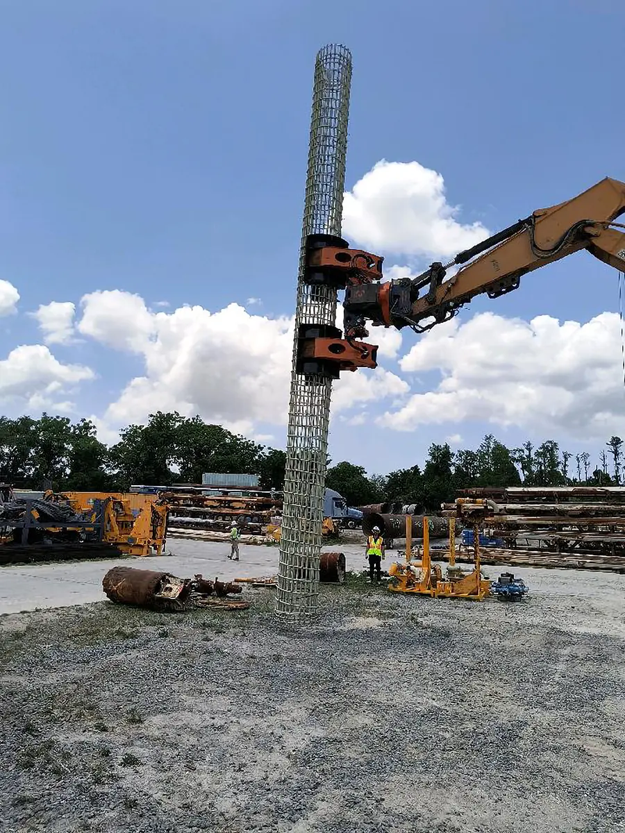 DECKHAND® excavator attachment with a modified Pipe Arm handles a pile cage during pile installation